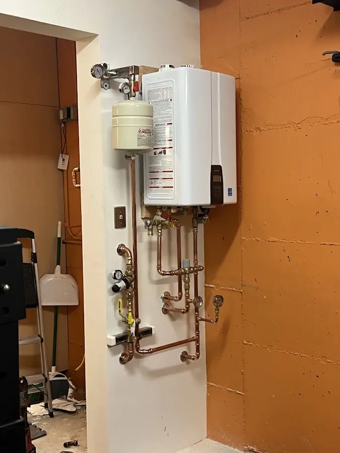 Plumbing technician inspecting water heater connections in Minnetonka